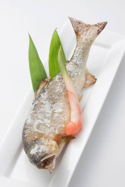 Yeşil yapraklı lezzetli ızgara balık.