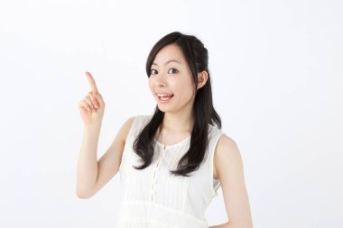 Asyalı bir kadın beyaz arka planda izole edilmiş bir şeyi işaret ediyor. 