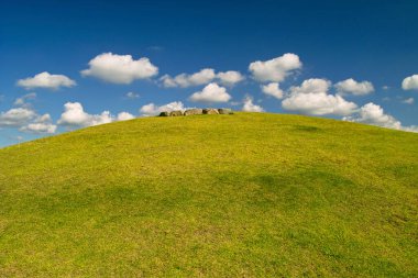 Güzel yeşil tepe tarlanın ortasında, mavi gökyüzü bulutlu