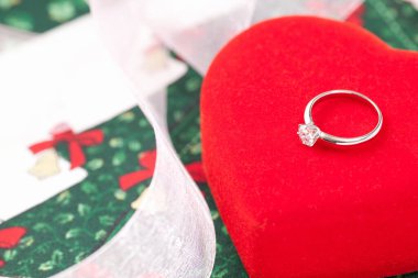 Kırmızı kalp şeklinde elmas yüzüklü değerli yüzüğün yakın plan görüntüsü.               