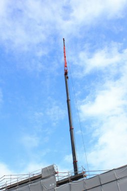 Parlak mavi gökyüzüne uzanan uzun bir vinç.