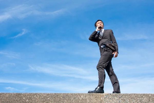 Ung Asiatisk Affärsman Med Telefon Kostym Himlen Bakgrund — Stockfoto