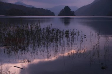 Dağlardaki sakin gölün üzerinde güzel bir gün batımı
