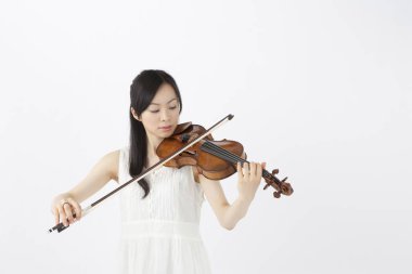 Stüdyoda keman çalan Asyalı kadın.