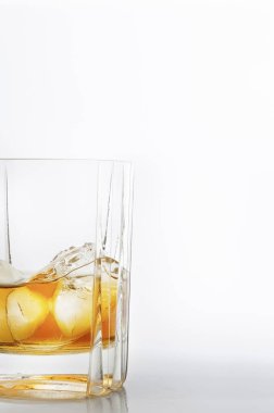 Beyaz zemin üzerinde buz küpleri olan bir bardak viski.