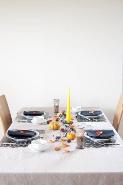 Balkabakları ve mumlarla şenlikli bir akşam yemeği için Şükran Günü sofrası.     