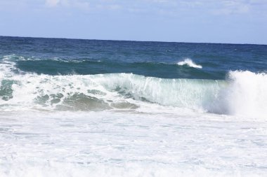 Sahile vuran köpüklü deniz dalgaları. 