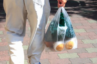 Naylon poşet taşıyarak.