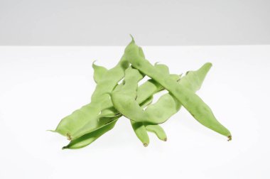 beyaz zemin üzerine yeşil fasulye bir demet.