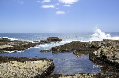 Dalgalar güzel kayalık kıyı şeridinde kırılıyor