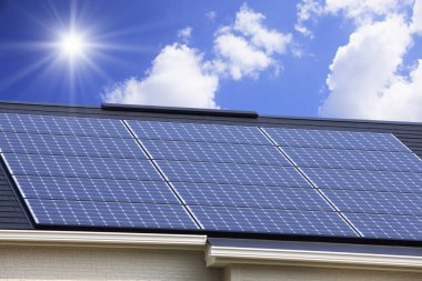 Çatıdaki güneş enerjisi panelleri bulutlu gökyüzüne karşı 