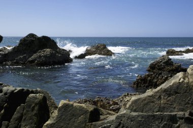 Sahildeki kayalar ve doğa arka planındaki mavi gökyüzü.