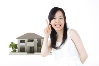 Beyaz arka planda ev modeli olan Asyalı kadın izole edilmiş.