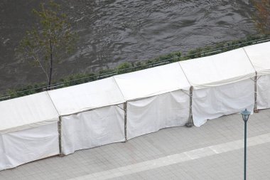 Nehir yolu boyunca beyaz çadırlar dizilmiş.