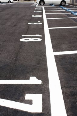 Siyah asfalt yolda beyaz park işaretleri 