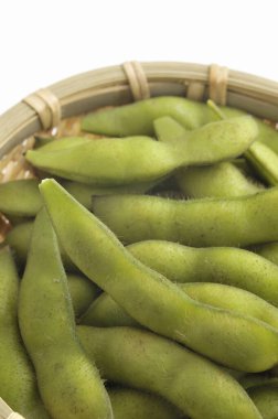 Beyaz arka planda sepette yeşil organik fasulye        