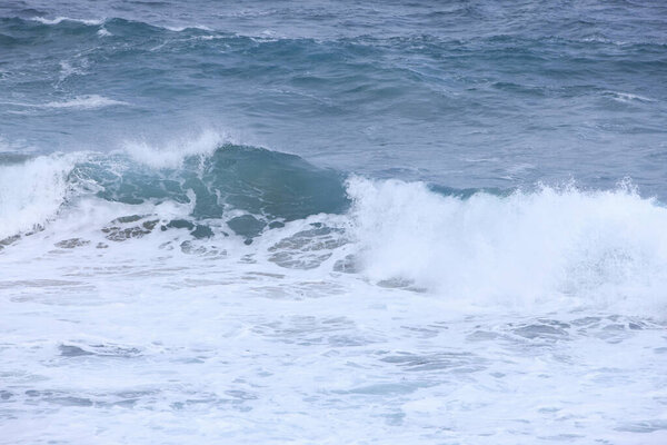 sea waves with foam crashing on beach 
