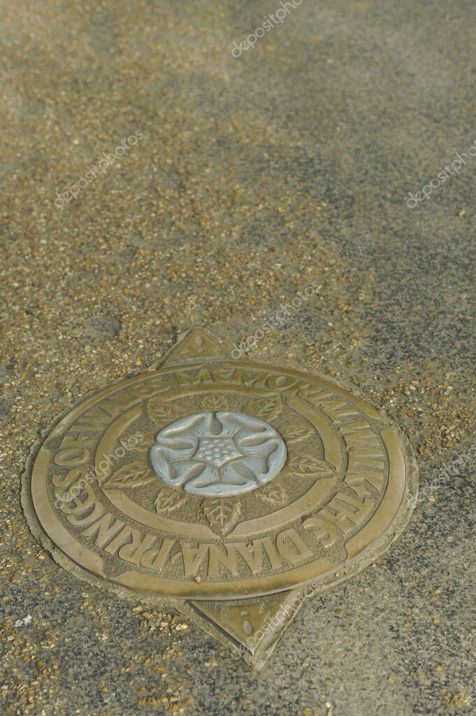 Metal manhole cover embedded in gravel surface outdoors