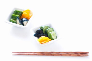 Beyaz arka planda izole edilmiş yemek çubukları olan sebzeler