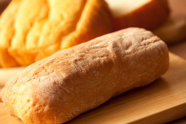 Arka plandaki masada dilimlenmiş taze ekmek, yakın plan.