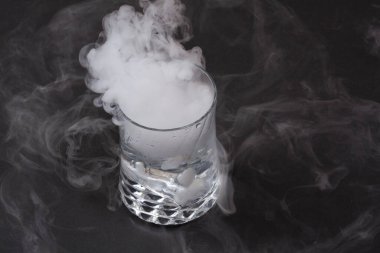 Koyu arkaplanda kuru buzun etkisi olan beyaz duman.