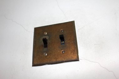 Kırık duvardaki eski çift lamba anahtarı.