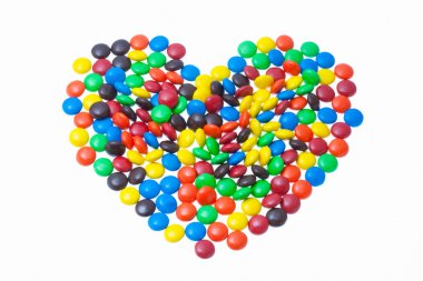 kalp beyaz arka planda renkli şekerlerden yapılmıştır.