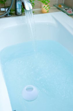 Küveti ve suyu olan modern banyo. 