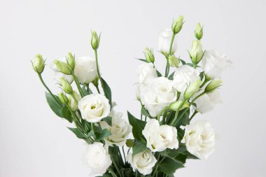 Beyaz arkaplanda bir buket beyaz gül