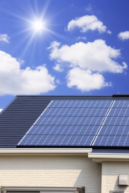 Çatıdaki güneş enerjisi panelleri bulutlu gökyüzüne karşı 