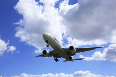 Mavi gökyüzünde beyaz bulutlu ve güneşli bir uçak..