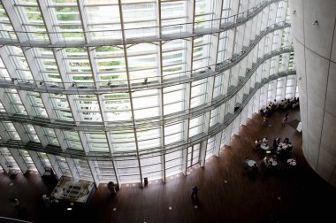 Şehir merkezinde modern cam bina ve insanlar