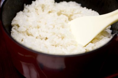 Bir kase kaynamış pirinç ve kaşık.