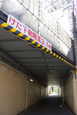 Gün ışığı dar şehir tünelinde iskele altında parlıyor.