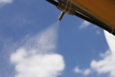 Kapalı su, parlak mavi gökyüzü bulutlarına püskürtüyor.