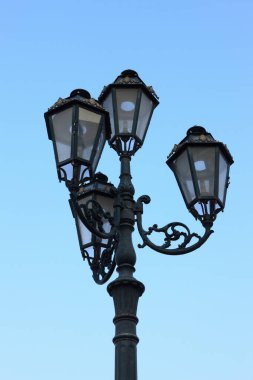 Mavi gökyüzü arka planında siyah sokak lambası