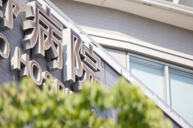 Geniş metalik tabelalı modern hastane dışı bina.