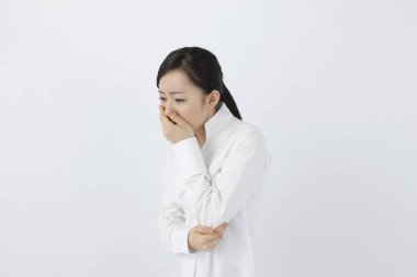 Genç hasta Asyalı kadın beyaz arka planda izole edilmiş. 