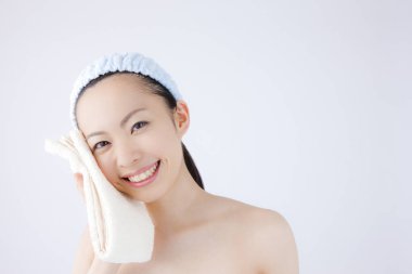 Genç ve güzel Asyalı kadın günlük cilt bakımını yapıyor.