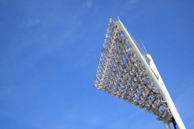 Büyük metal yapısı ve mavi gökyüzü olan bir stadyum.