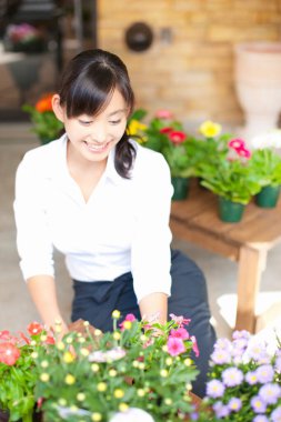 Dükkanda çalışan genç Japon kadın çiçekçinin portresi.