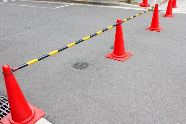 Açık turuncu trafik konileri boş şehir caddesini engelliyor