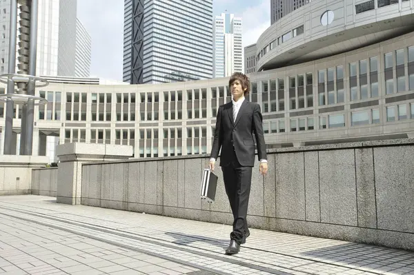 elegant businessman with briefcase walking outdoors