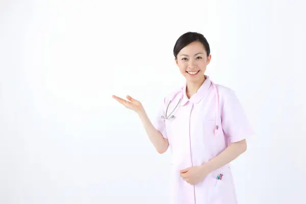 Porträt Einer Jungen Krankenschwester Die Etwas Auf Weißem Hintergrund Zeigt — Stockfoto
