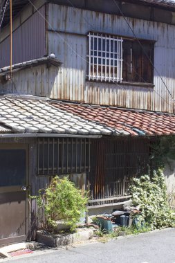 Paslı metal ve bitkilerle kaplanmış eski bir bina.