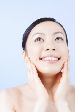 Genç ve güzel Asyalı kadın günlük cilt bakımını yapıyor.