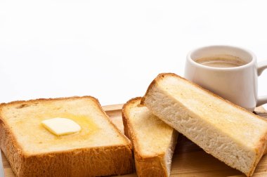 Arka planda tereyağlı ve kahveli taze ekmek.