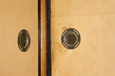 Dairesel metal sapları yakın çekim gösteren iki tahta panel.