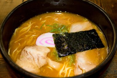 Bir kase yosun ve domuz dilimli ramen.