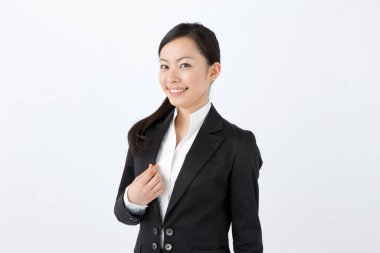 Beyaz arka planda takım elbiseli genç Asyalı kadın. 